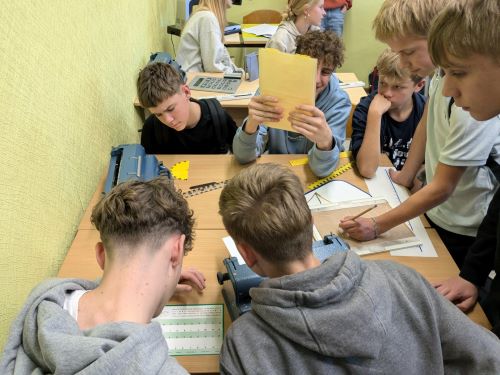 8.klašu skolēni, viesojoties Strazdmuižas vidusskolā, pēta neredzīgiem skolēniem piemērotos mācību materiālus.